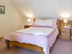 a bedroom with a bed and two lamps on tables at 2 Sawmill Cottages in Puncknowle