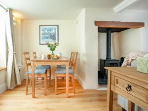 ein Esszimmer mit Tisch und Holzofen in der Unterkunft Otters Cottage in Ottery Saint Mary