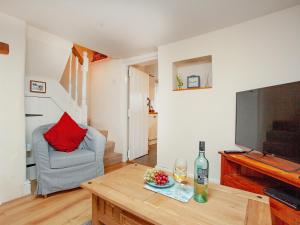 ein Wohnzimmer mit Fernseher und Tisch in der Unterkunft Otters Cottage in Ottery Saint Mary