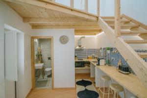uma cozinha com um balcão e uma escada num quarto em Loft 11 em Olhão