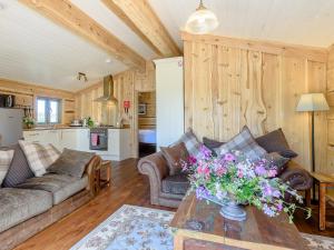 a living room with a couch and a table with flowers on it at Kingfisher Cabin in Croft