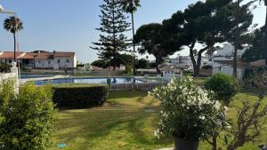 a yard with a swimming pool and trees and bushes at Sunny Sea Garden Apartment in Mijas Costa