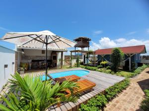 a villa with a swimming pool and a house at Chalé Entre Ciclos Icaraizinho in Amontada