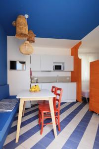 a kitchen with a table and chairs and a blue wall at A' Terrazza in Santa Flavia