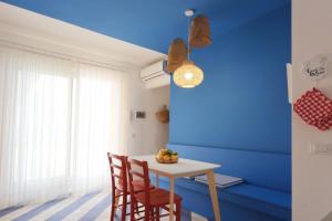 a dining room with blue walls and a table and chairs at A' Terrazza in Santa Flavia