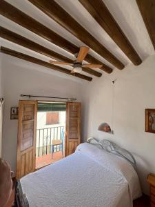 una camera da letto con un letto e un ventilatore a soffitto di Casa Estrella de la Alpujarra a Almegíjar