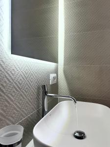 a bathroom with a white sink and a mirror at Luxenti Luxury Rooms in Cagliari +30 photos