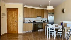 eine Küche mit Holzschränken und einem Tisch und Stühlen in der Unterkunft 1-bedrooms apartament Vista Roja, La Tejita in Granadilla de Abona