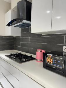 a kitchen with a stove and a microwave at Opus Luxury Family Serviced Apartments Gulberg Lahore in Lahore +10 photos