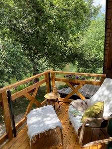 a wooden deck with two chairs and a table at Vacation Home Pliva in Šipovo