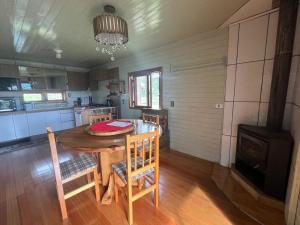 a kitchen with a table and chairs and a stove at Cabanas Romeu & Julieta in Cambará