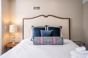 una camera da letto con un letto bianco con cuscini blu di Stay in Abbey Springs 2 BDR with Resort Amenities a Lake Geneva Altre 39 foto