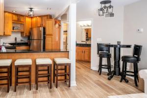 a kitchen with a bar with stools and a refrigerator at Stay in Abbey Springs 2 BDR with Resort Amenities in Lake Geneva