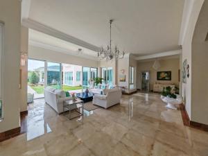 un ampio soggiorno con mobili bianchi e ampie finestre di Casa de Campo Luxury Villa with private Pool & Jacuzzi, Near Beach, Marina, Golf, Restaurants & Altos de Chavon a La Romana