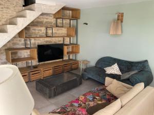 PujautにあるMaison de village de caractèreのソファと薄型テレビのあるリビングルーム