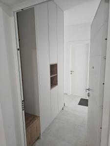 ein Flur mit weißen Wänden und einer Tür zu einem Zimmer in der Unterkunft Dvosoban stan Akacija Trebinje in Trebinje