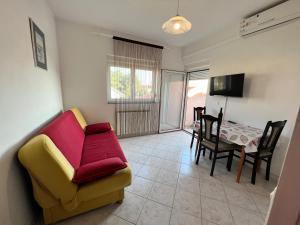 a living room with a yellow couch and a table at Apartmani Dorana in Vrsi