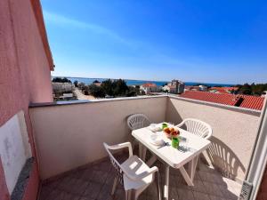 a white table and chairs on a balcony at Apartmani Dorana in Vrsi