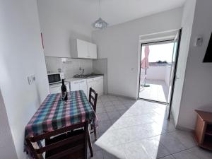 a kitchen with a table with a bottle of wine on it at Apartmani Dorana in Vrsi +107 photos