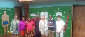 a group of people standing in front of a wall at Gift Homestay in Karatu