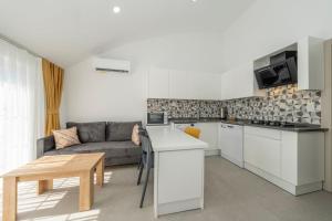 a living room with a couch and a kitchen at Dede Suites Fethiye in Fethiye +23 photos