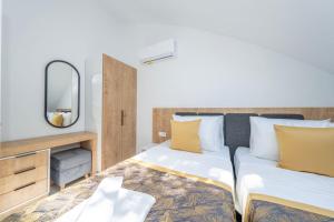 a bedroom with two beds with a mirror and a tv at Dede Suites Fethiye in Fethiye