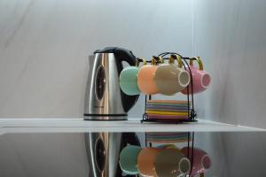 two coffee cups and a tea kettle on a shelf at Apartman Boutique in Sarajevo