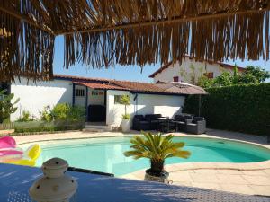 a swimming pool in front of a house at Chalet Zure Ondoan - SPA et piscine chauffée in Tarnos