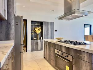 cocina con electrodomésticos de acero inoxidable y fogones en Luxury Beachfront Condo 3BR 3BA with stunning views, en Tijuana