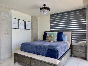 Un dormitorio con una cama con un edredón azul. en Luxury Beachfront Condo 3BR 3BA with stunning views, en Tijuana 31 fotos más