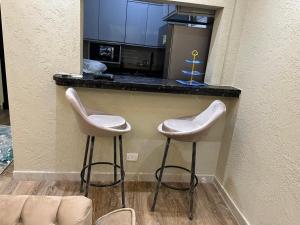 two white stools sitting at a kitchen counter at marhaba madinaty 34 in Madinaty