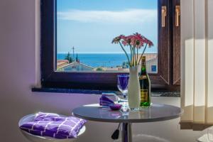 a table with a vase of flowers and a window at Holiday Home & Apartments Primavera in Pula