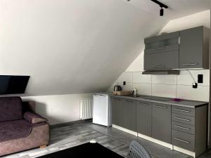 a small kitchen with a couch and a refrigerator at Wynajem Pokoi JULIA in Krynica Morska