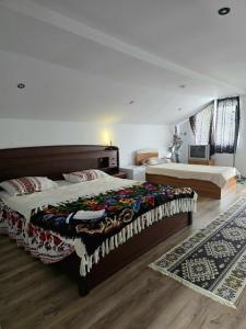 a bedroom with two beds and a rug at Casa Roxana in Vişeu de Mijloc