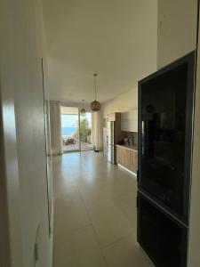 a large living room with a television and a kitchen at Calma View Apartment Green Coast in Palasë