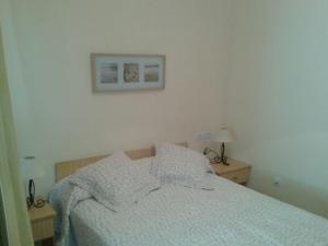 1 dormitorio con 1 cama y 2 mesas con lámparas en Apartamentos Creoli, en Ayamonte