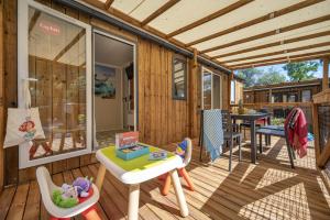a house with a deck with a table and chairs at Vakantiepark het Wieskamp in Henxel