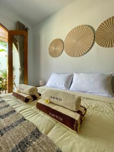 a bedroom with two towels on a bed at Alma Nusa Penida in Nusa Penida