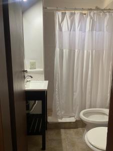 a bathroom with a white shower curtain and a toilet at Del Prado in San Carlos de Bariloche