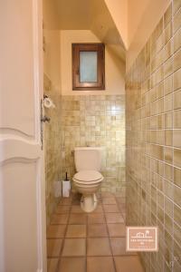 a bathroom with a toilet and a window on the wall at Maison de la Rade, sea view and air conditioning in Saint-Mandrier-sur-Mer