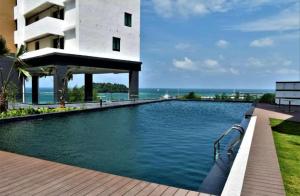 a swimming pool in front of a building at PD DWharf Hotel Suite & Serviced Residence in Port Dickson
