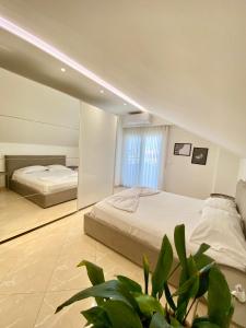 a bedroom with two beds and a large mirror at Lovely Rooftop Apartment in Golem +49 photos