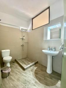 łazienka z umywalką, toaletą i lustrem w obiekcie Summer Rooms w mieście Skala Kallirachis