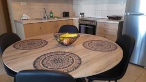 a kitchen with a wooden table with a bowl on it at Ifigeneia Infinity Suites in Néa Alikarnassós