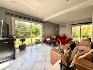 un soggiorno con un divano e una TV di Maison Occitane avec Piscine a Béziers