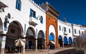 a large white building with an umbrella on a street at Casa Abdel in Larache