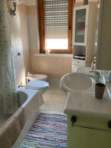 a bathroom with a sink and a toilet and a tub at Casa Il Carmine in Alghero