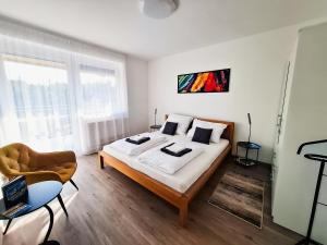 a bedroom with a large bed and a chair at PartON Keszthely in Keszthely