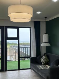 a living room with a couch and a large window at Souluna lodge in Chyrpykty