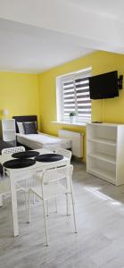 a room with white tables and chairs and a yellow wall at Willa Sonia in Władysławowo +25 photos